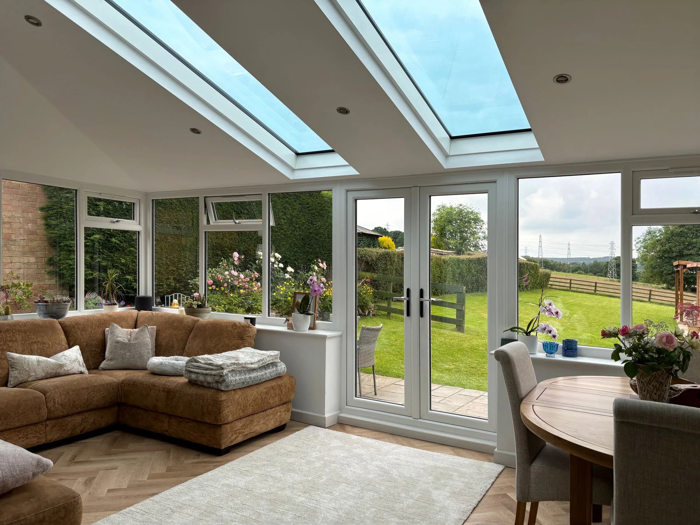 A sitting room under the plastered ceiling and roof glazing of a SupaLite lightweight tiled conservatory roof.