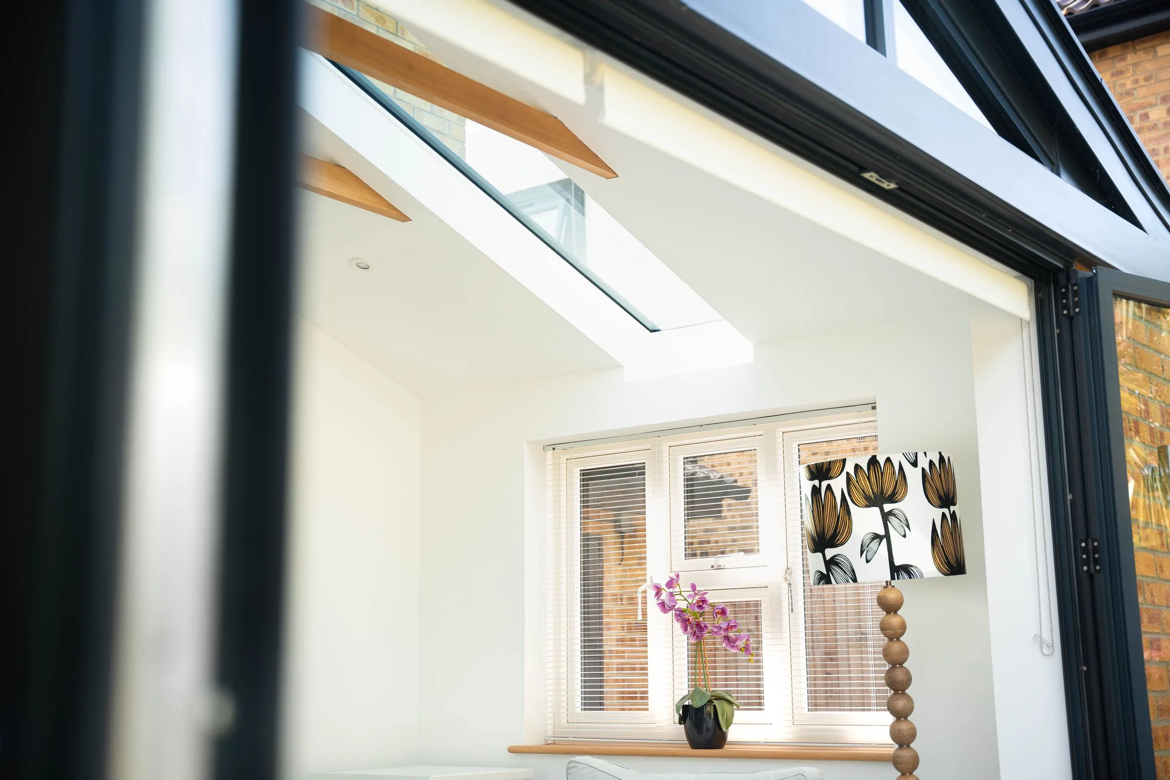 The vaulted plastered ceiling of a WarmerRoof insulated conservatory roof, with a roof window set into the slope.